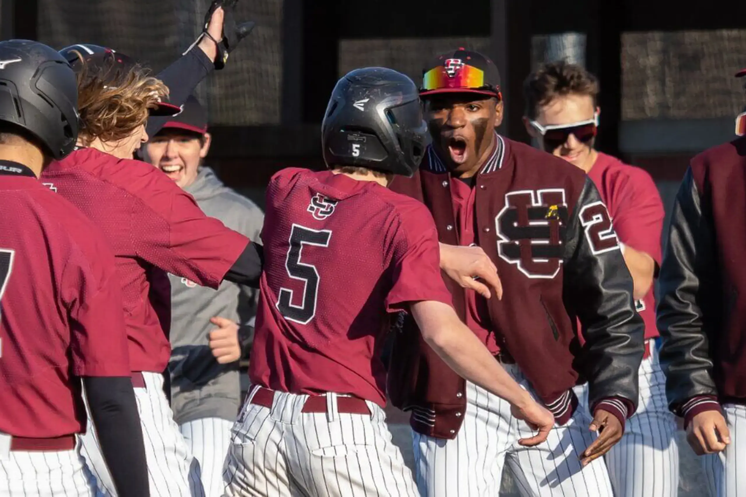 University School Baseball team celebrating after a game on the baseball diamond.