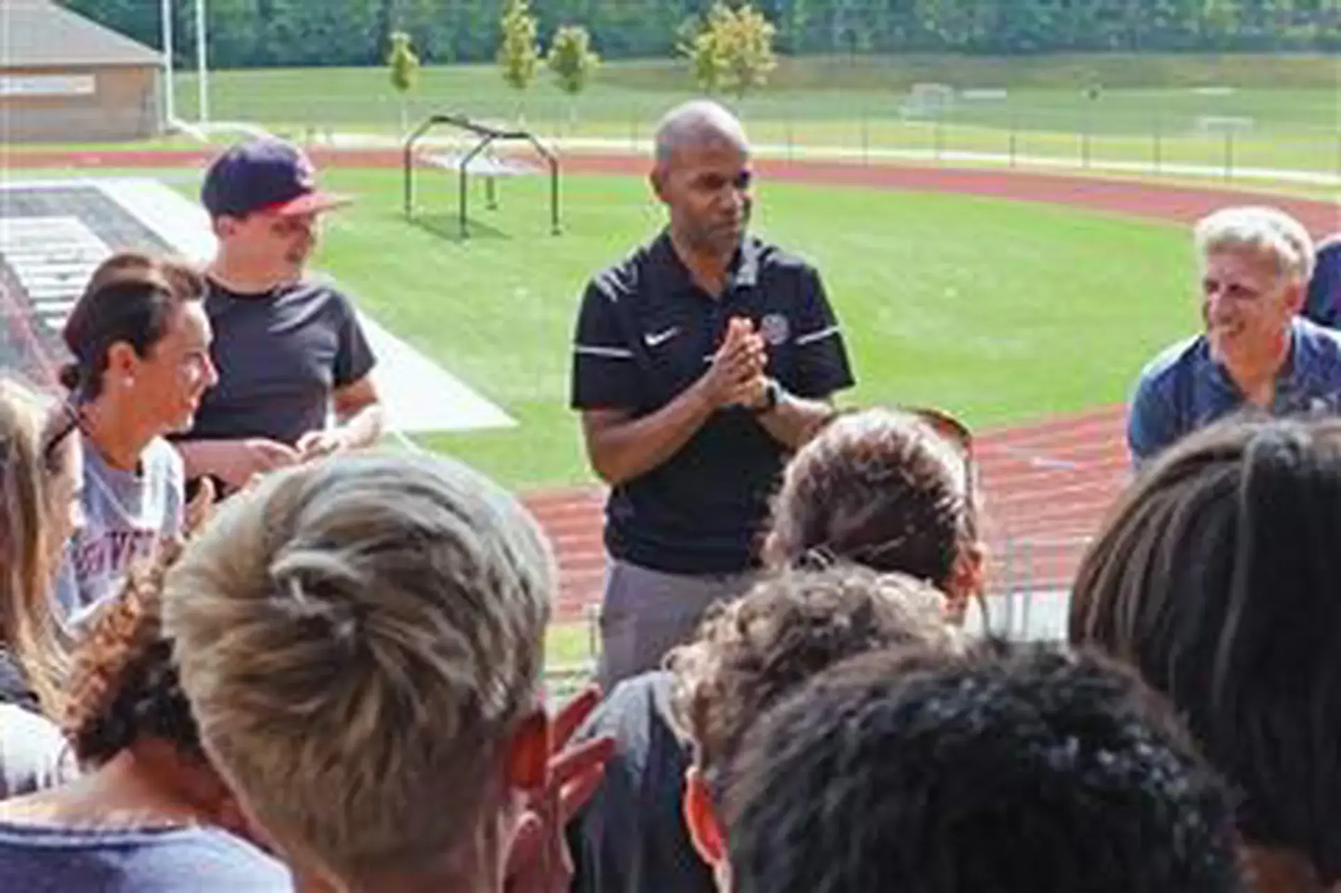 Terry Lipford ’98 coaching students at an athletics field.