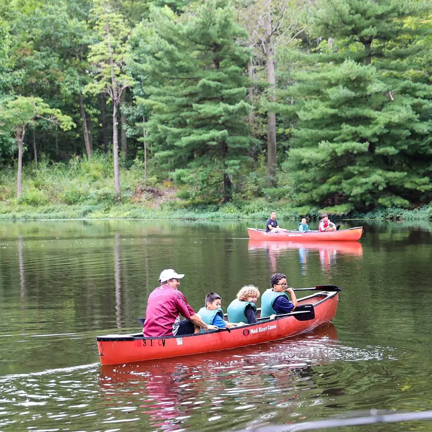 University School students and teachers canoeing on a lake.