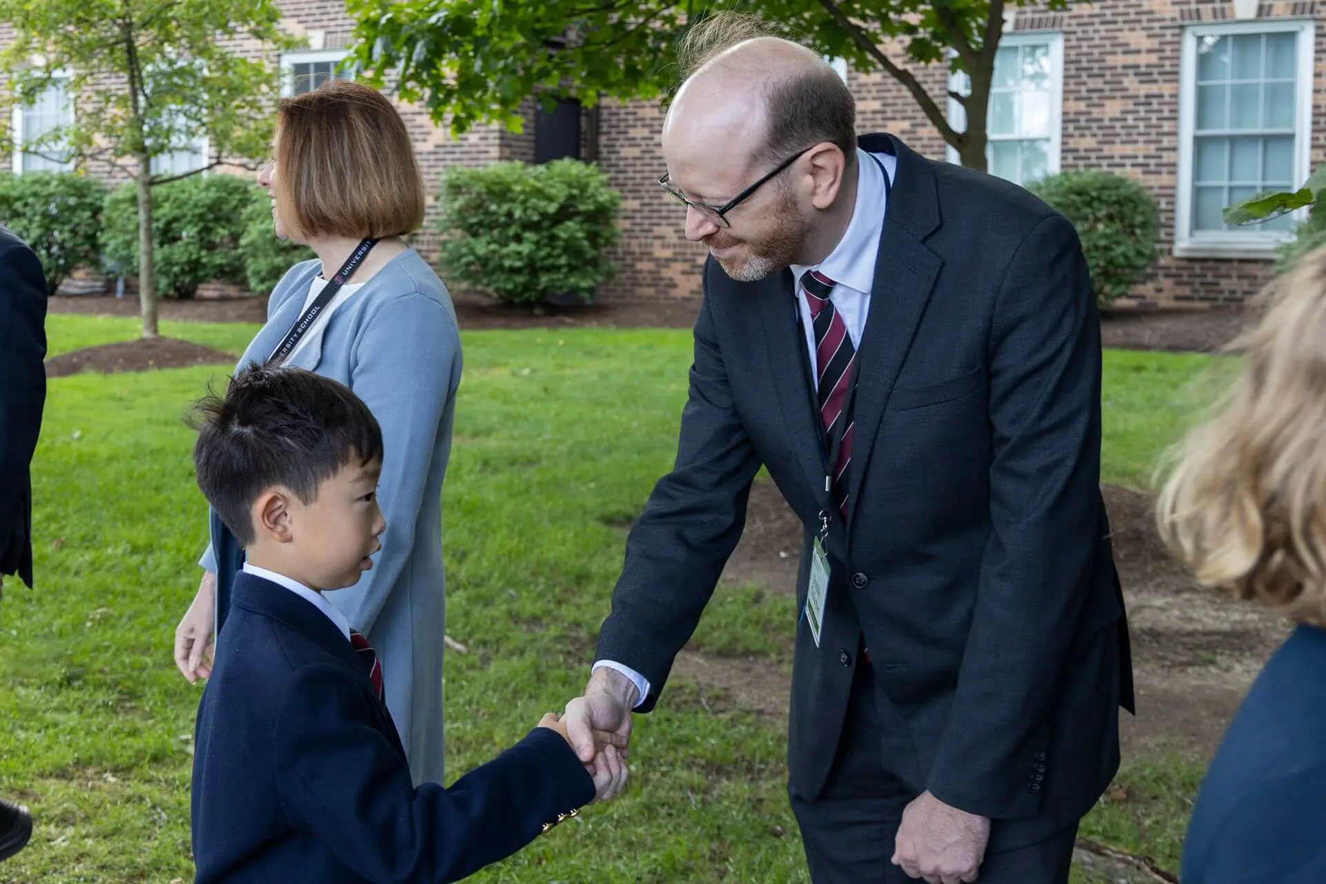 Patrick T. Gallagher, Head of School, greets student with a handshake.