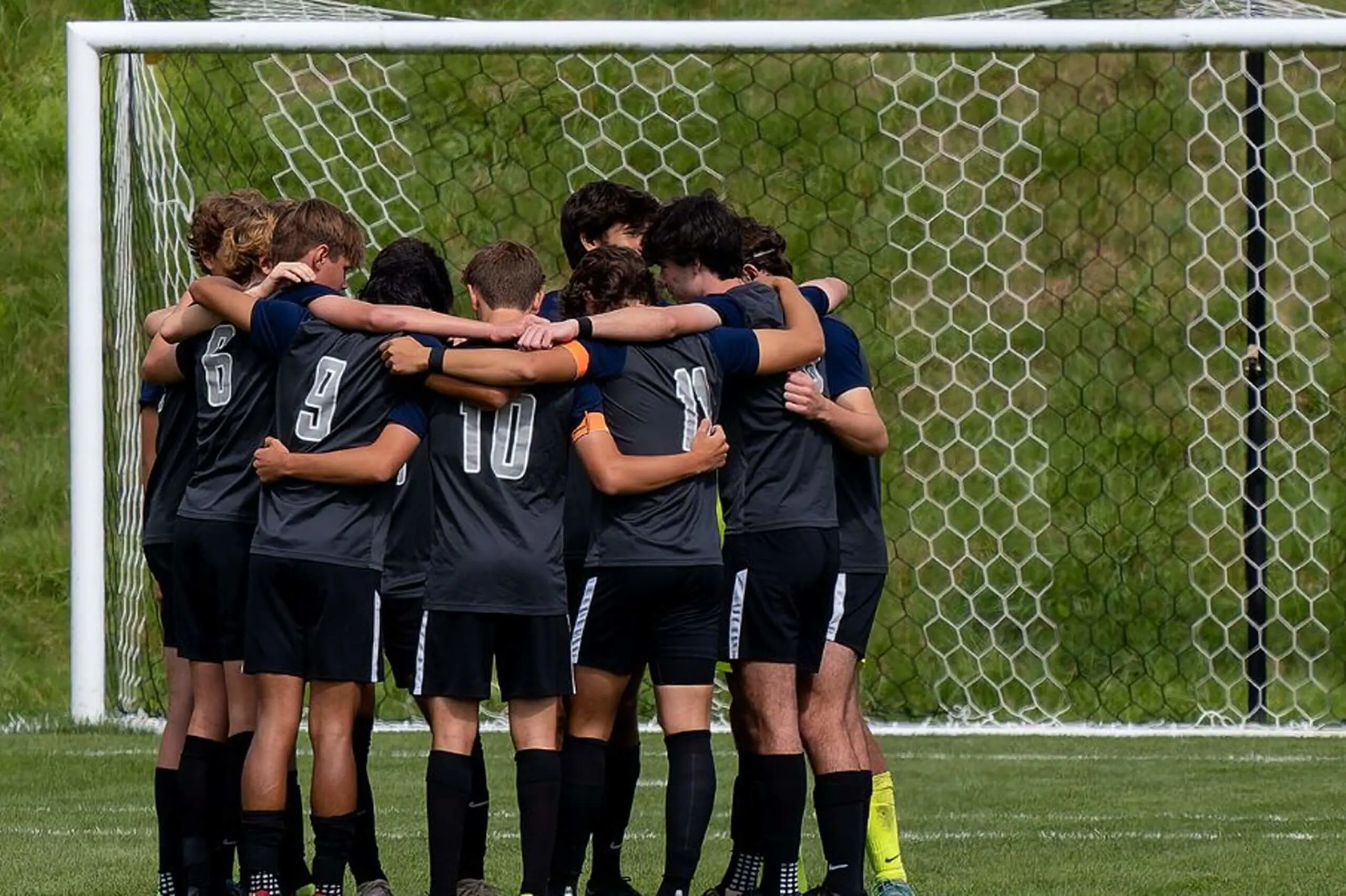 University School soccer team huddle by the goal.