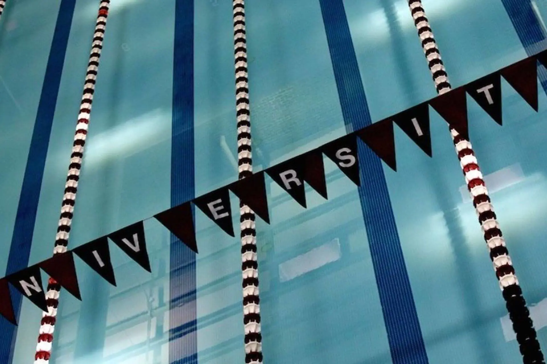 Overhead view of the swimming pool at University School, showing lane dividers and bunting reading 'University School'.
