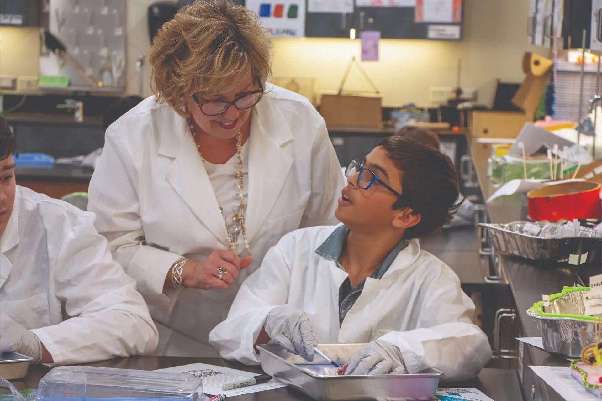 University School Middle School student dissecting a Sheep's eye in a Science lesson, discussing the process with their teacher.