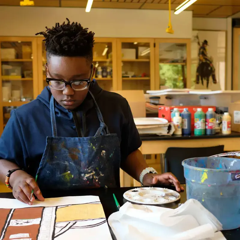 University School REACH Program student painting in an art class.