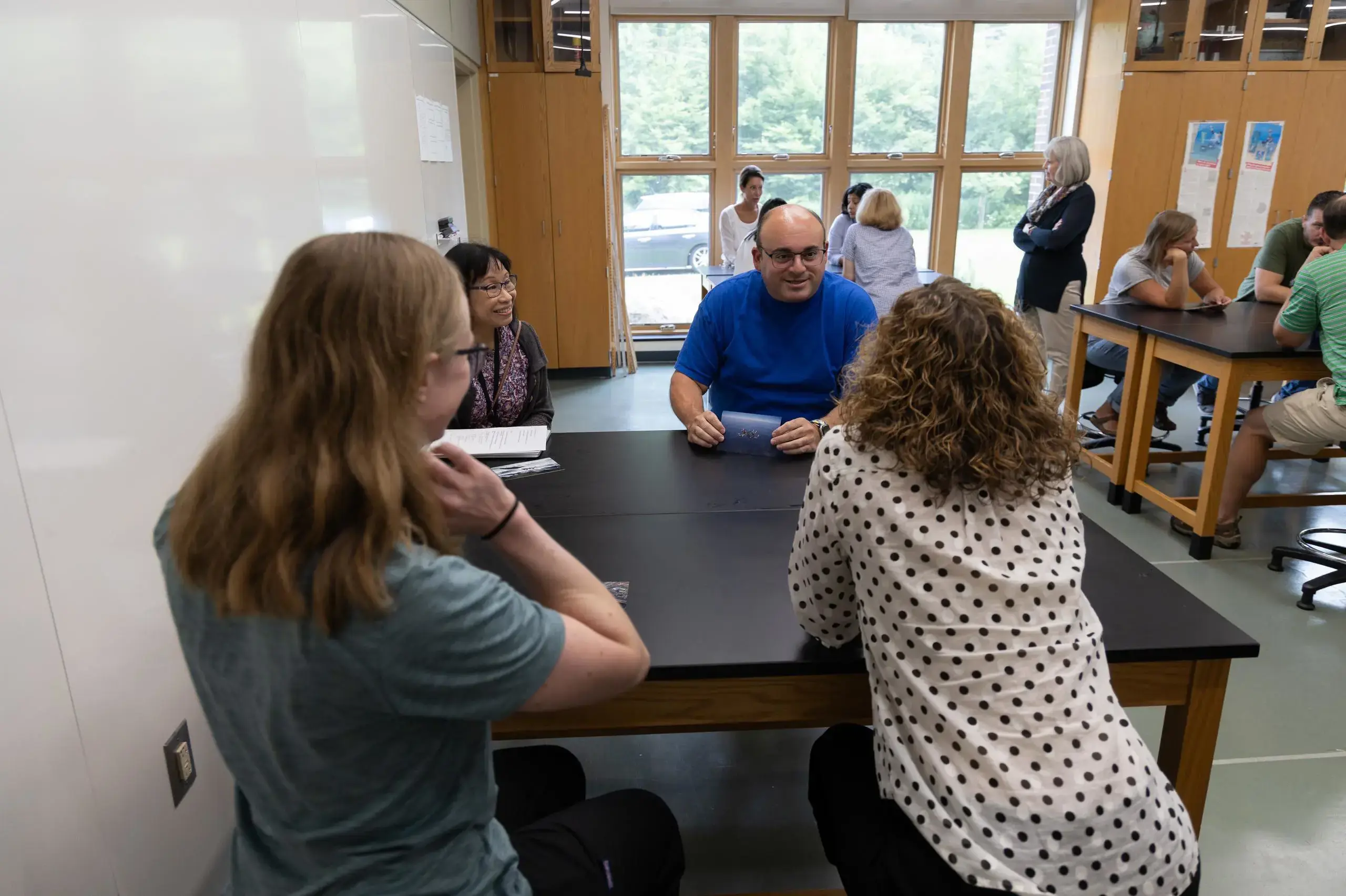 University School faculty sitting together, talking.