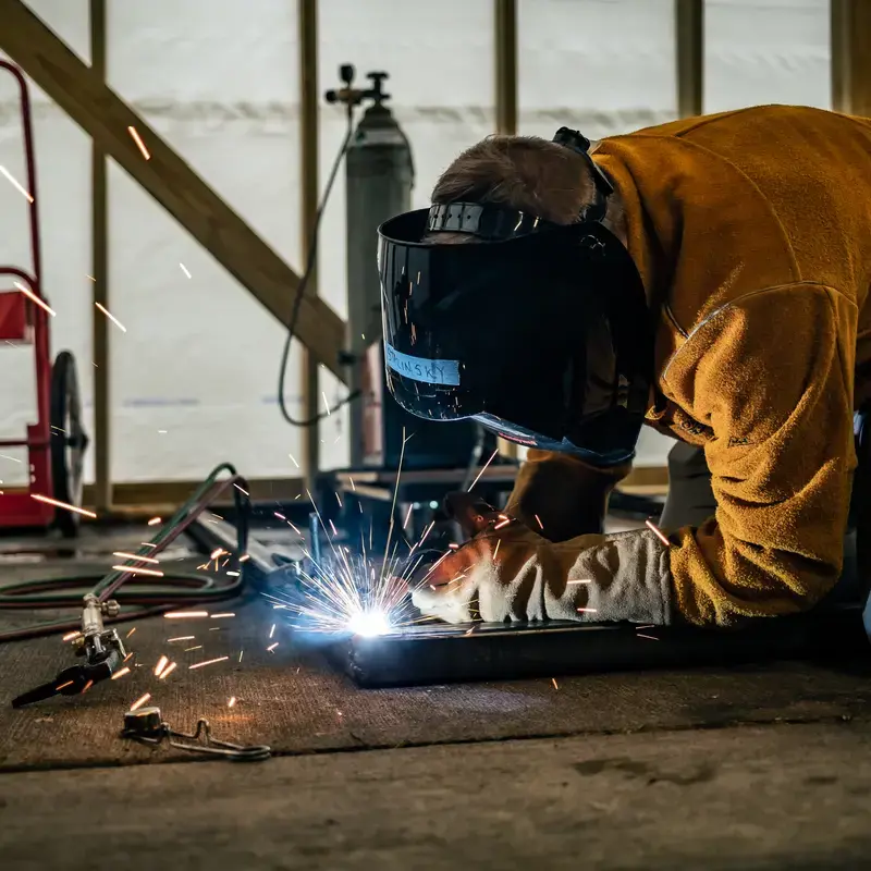 University School student welding as part of the Strnad Fellowship Program for their independent project.