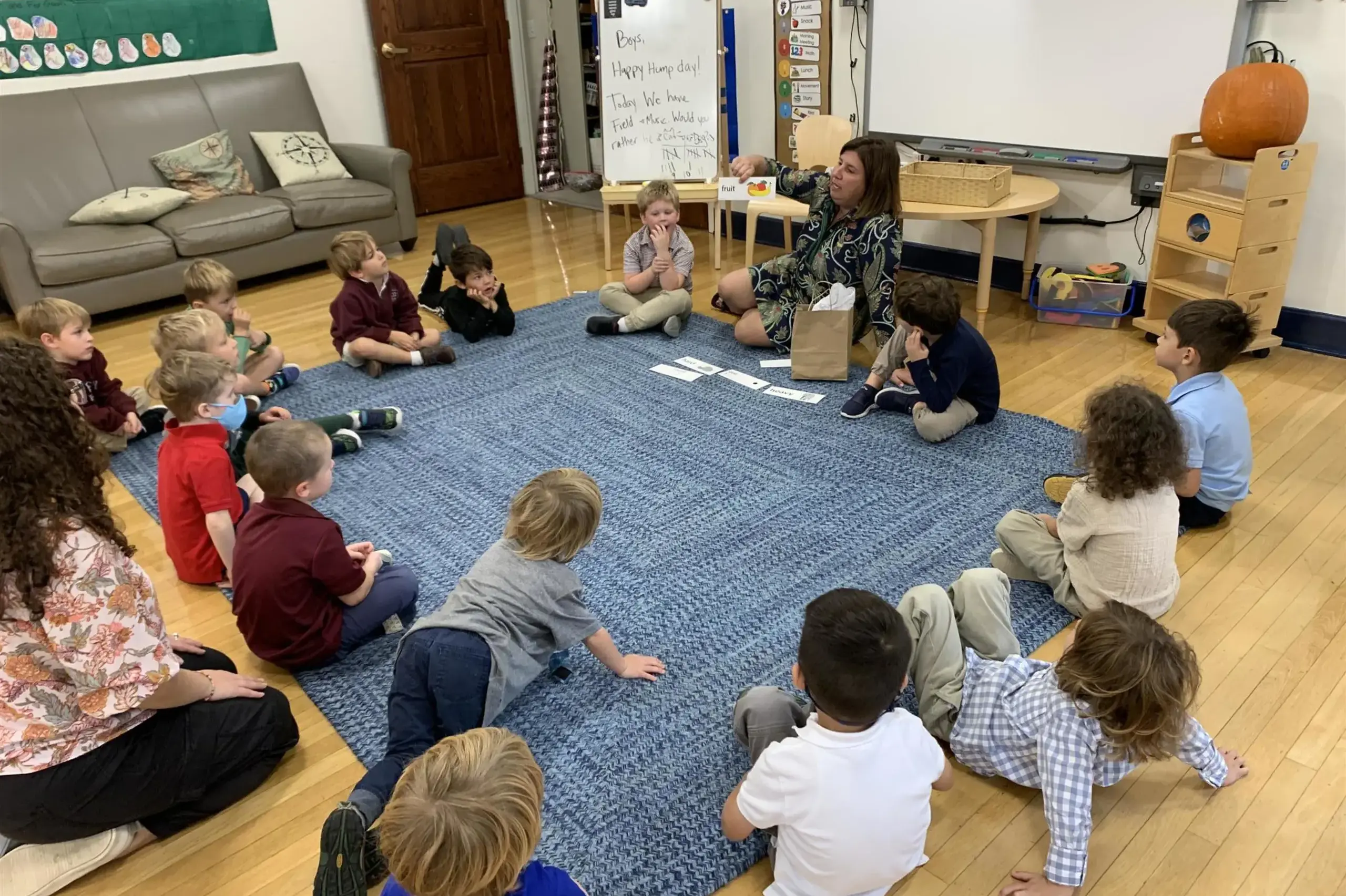 University School Lower School Junior Kindergarten students sit together in a circle on the carpet during Homeroom.