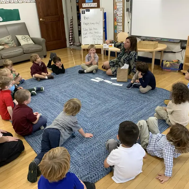 University School Lower School Junior Kindergarten students sit together in a circle on the carpet during Homeroom.