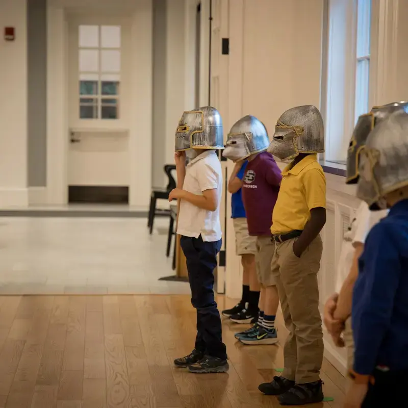 University School Kindergartners wearing medieval knight's helmets.