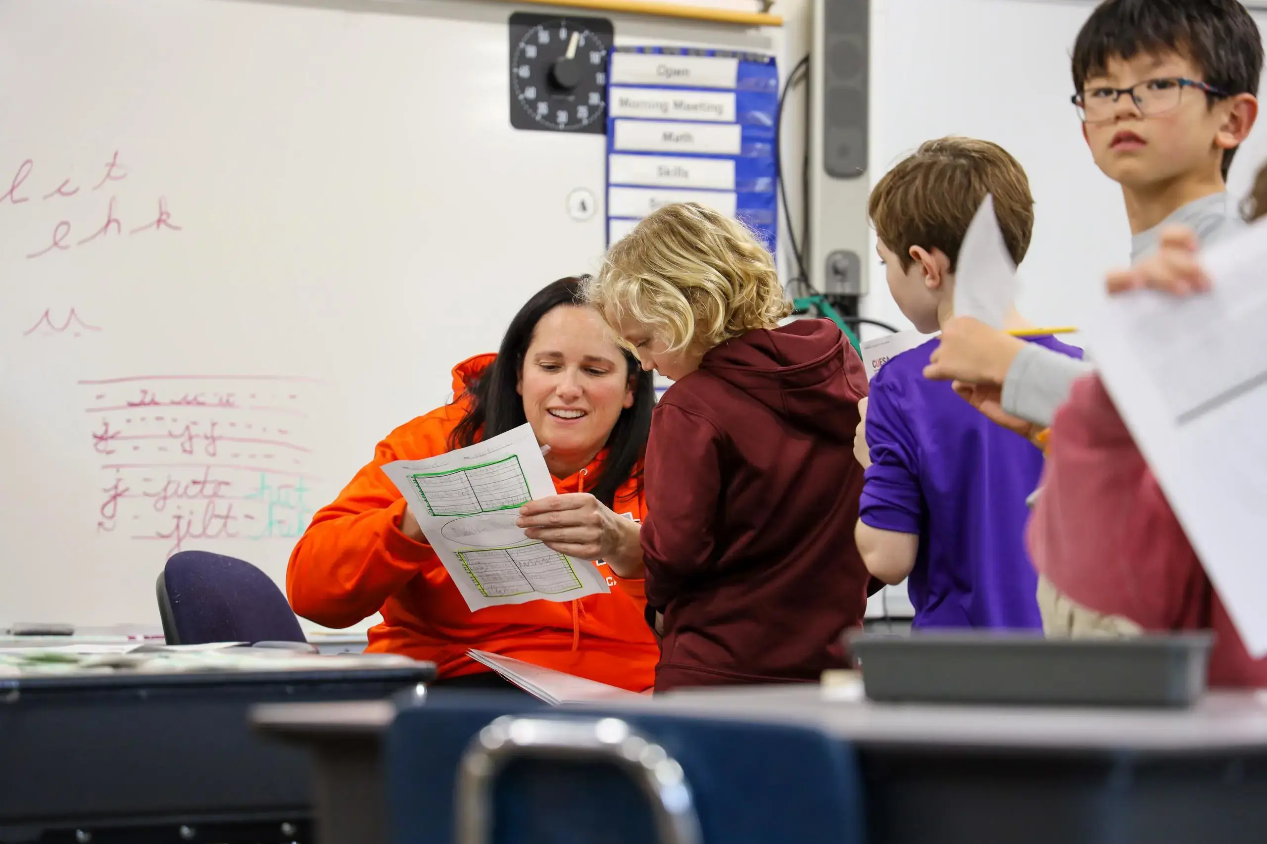 University School second grade teacher looking at worksheet with a student.