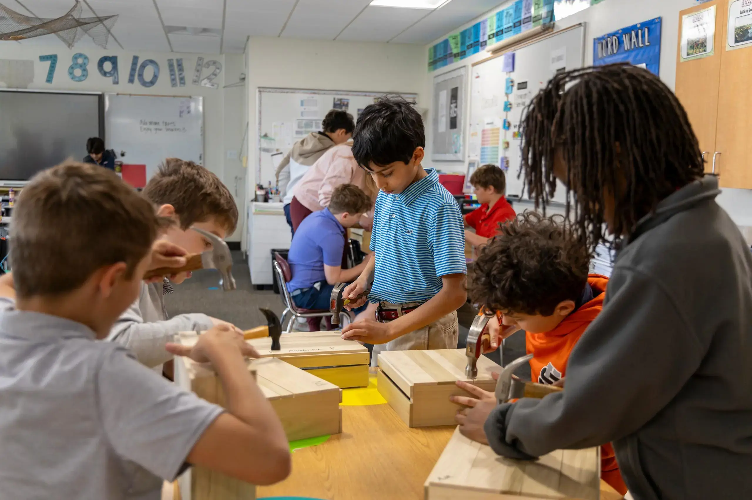 University School Lower School students making wooden boxes in a class, using hammers and nails.
