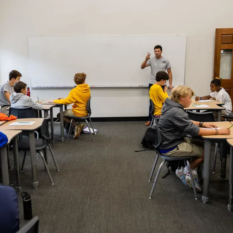 University School Middle School students listening attentively to a teacher in a Latin class.