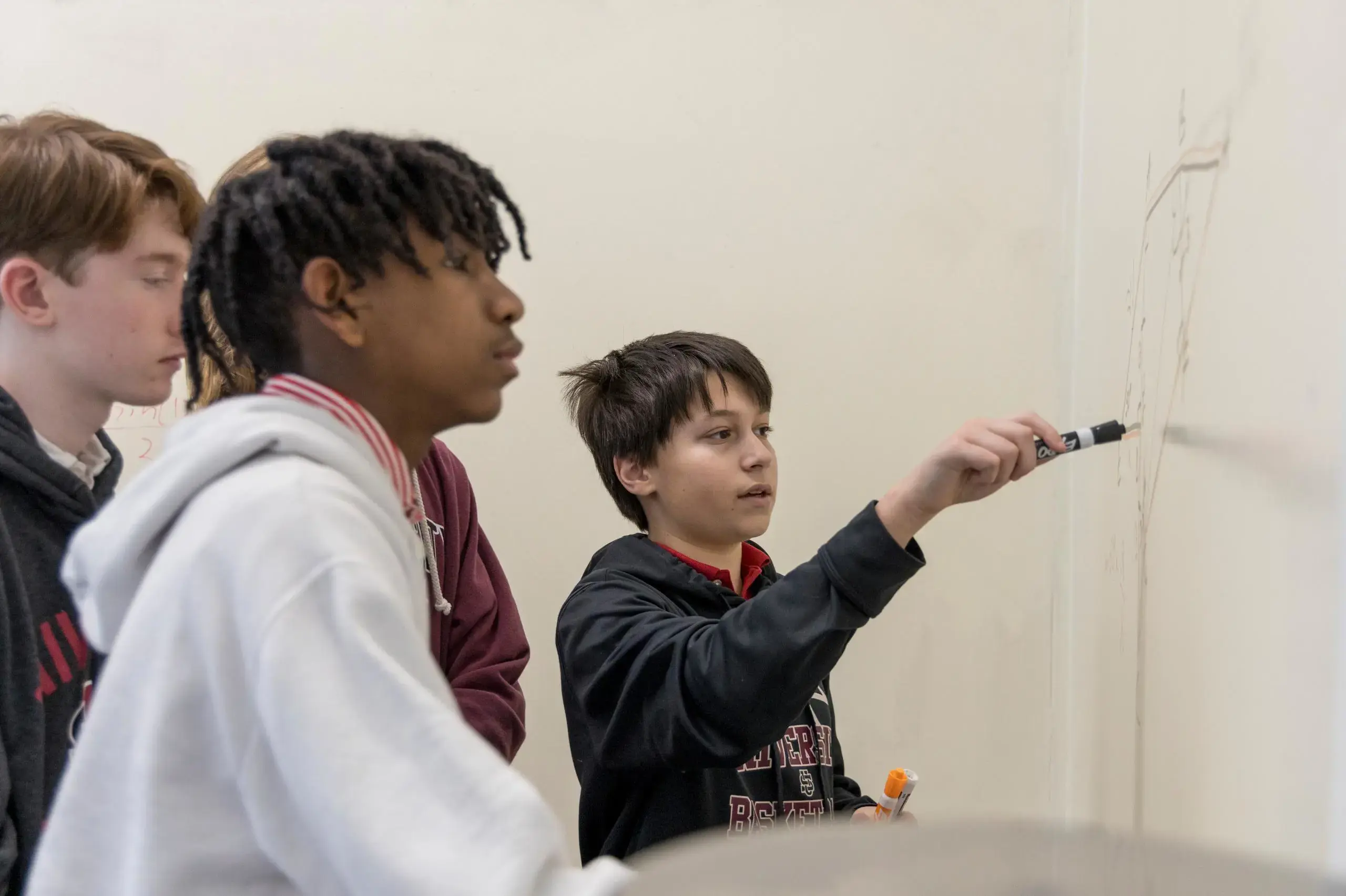 University School Middle School students solving equations together on the whiteboard in a math class.