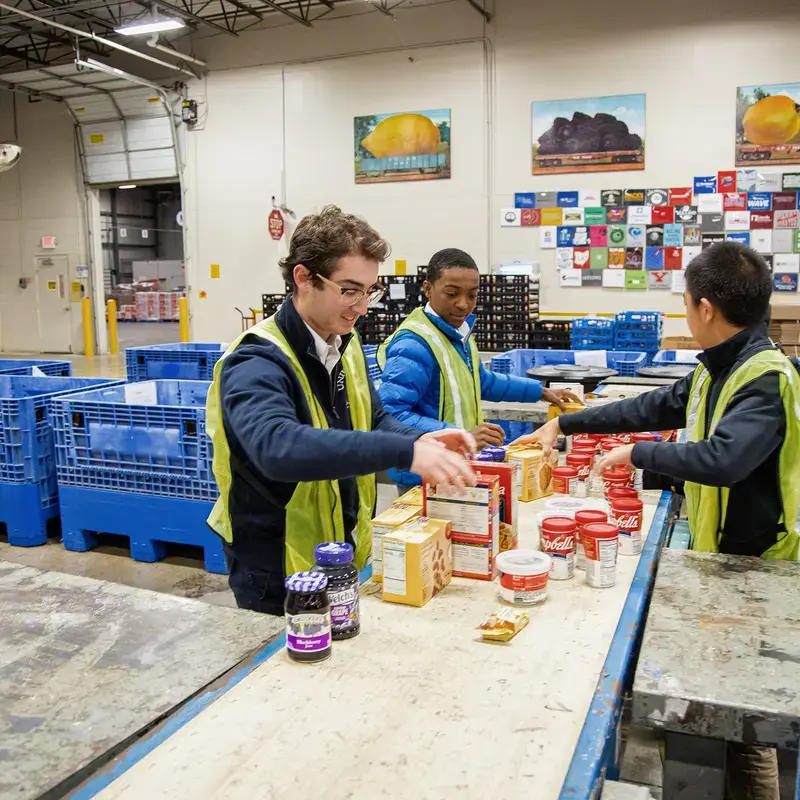 University School students wearing high vis vests sorting food donations as part of Community Engagement program.
