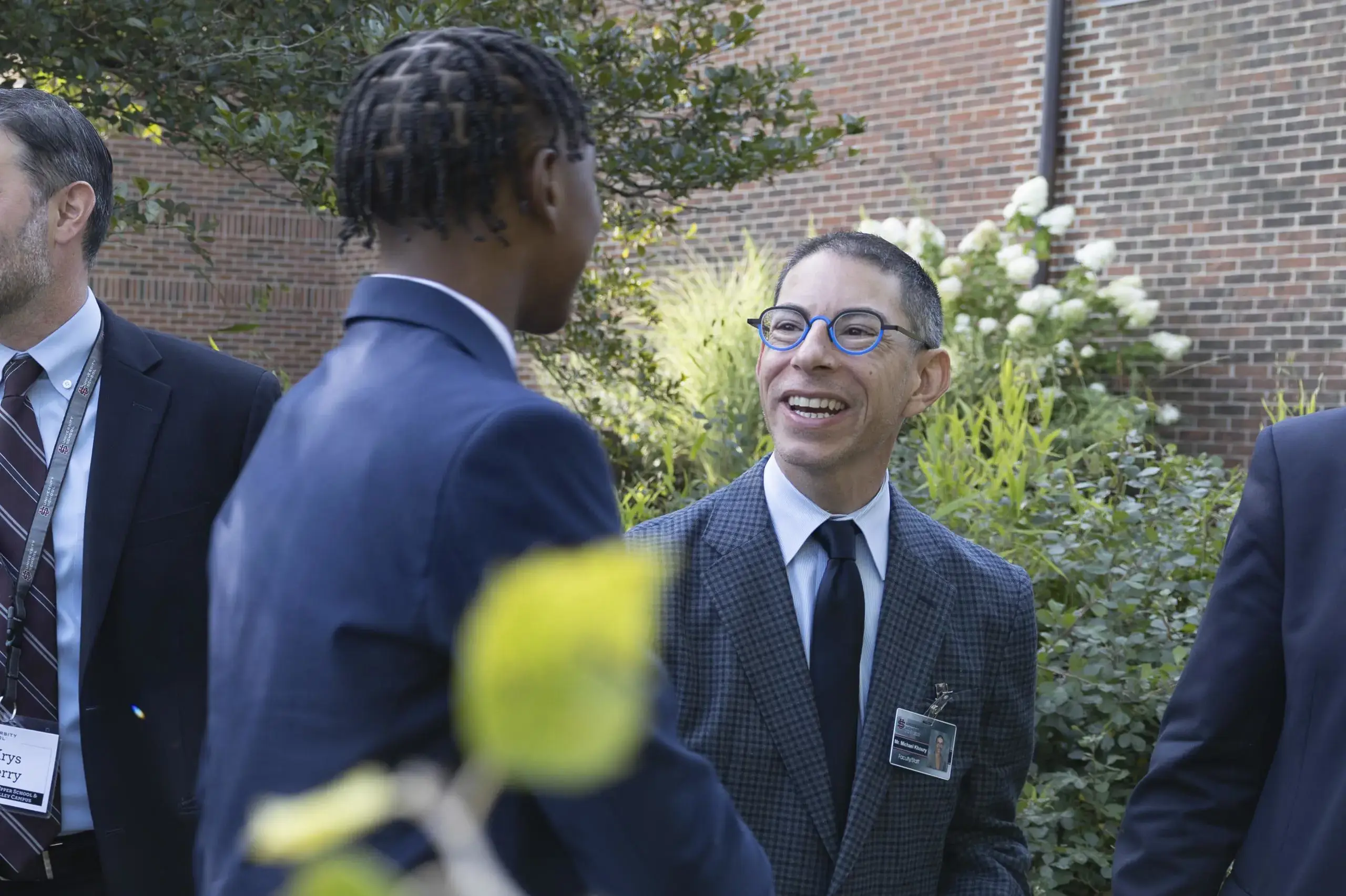 Member of University School's Upper School faculty shakes hands with a student, smiling warmly.