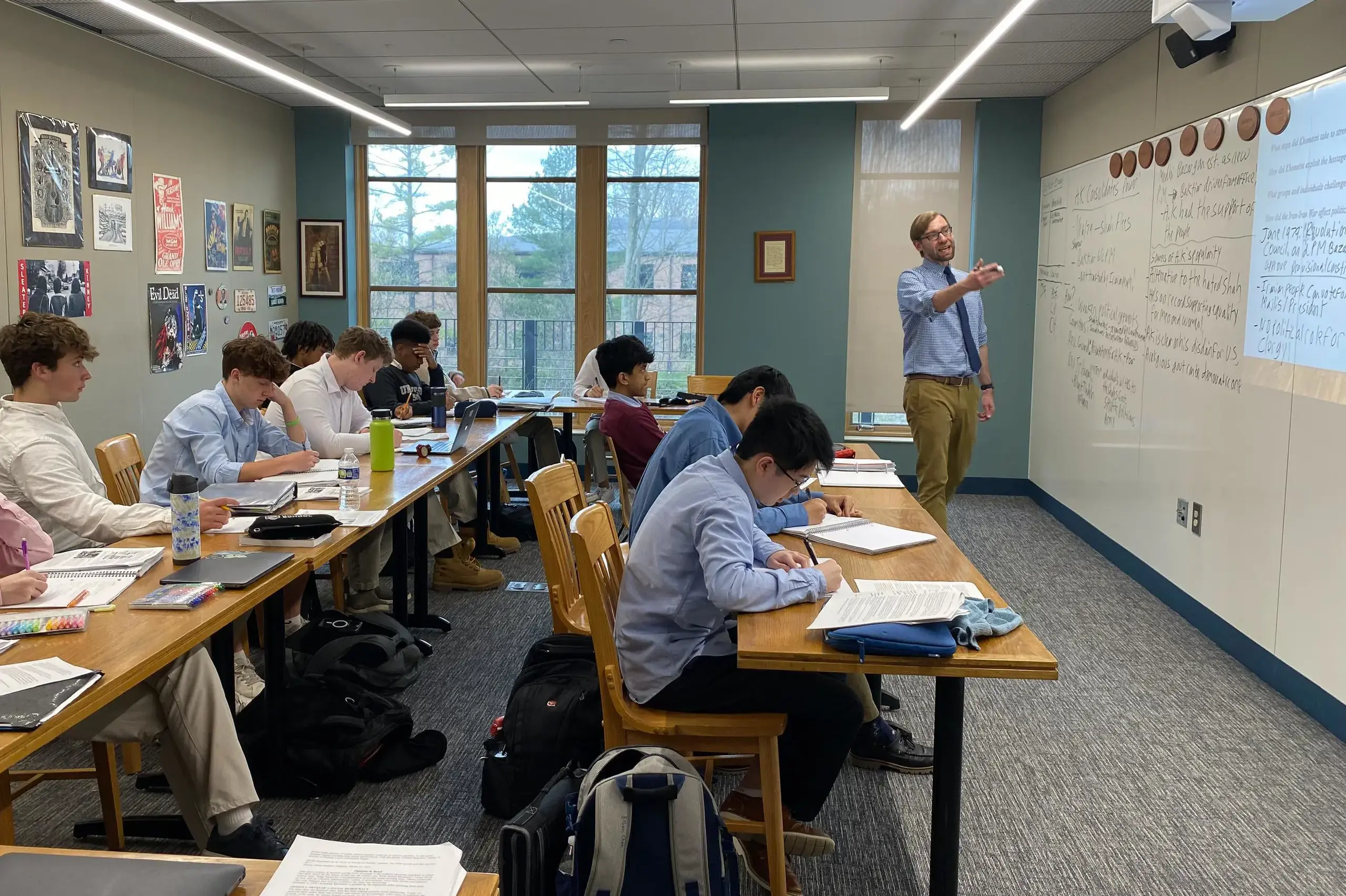 University School Upper School students taking notes as their teacher discusses their topic of study during a history class.