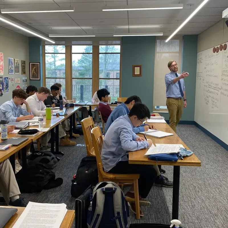University School Upper School students taking notes as their teacher discusses their topic of study during a history class.