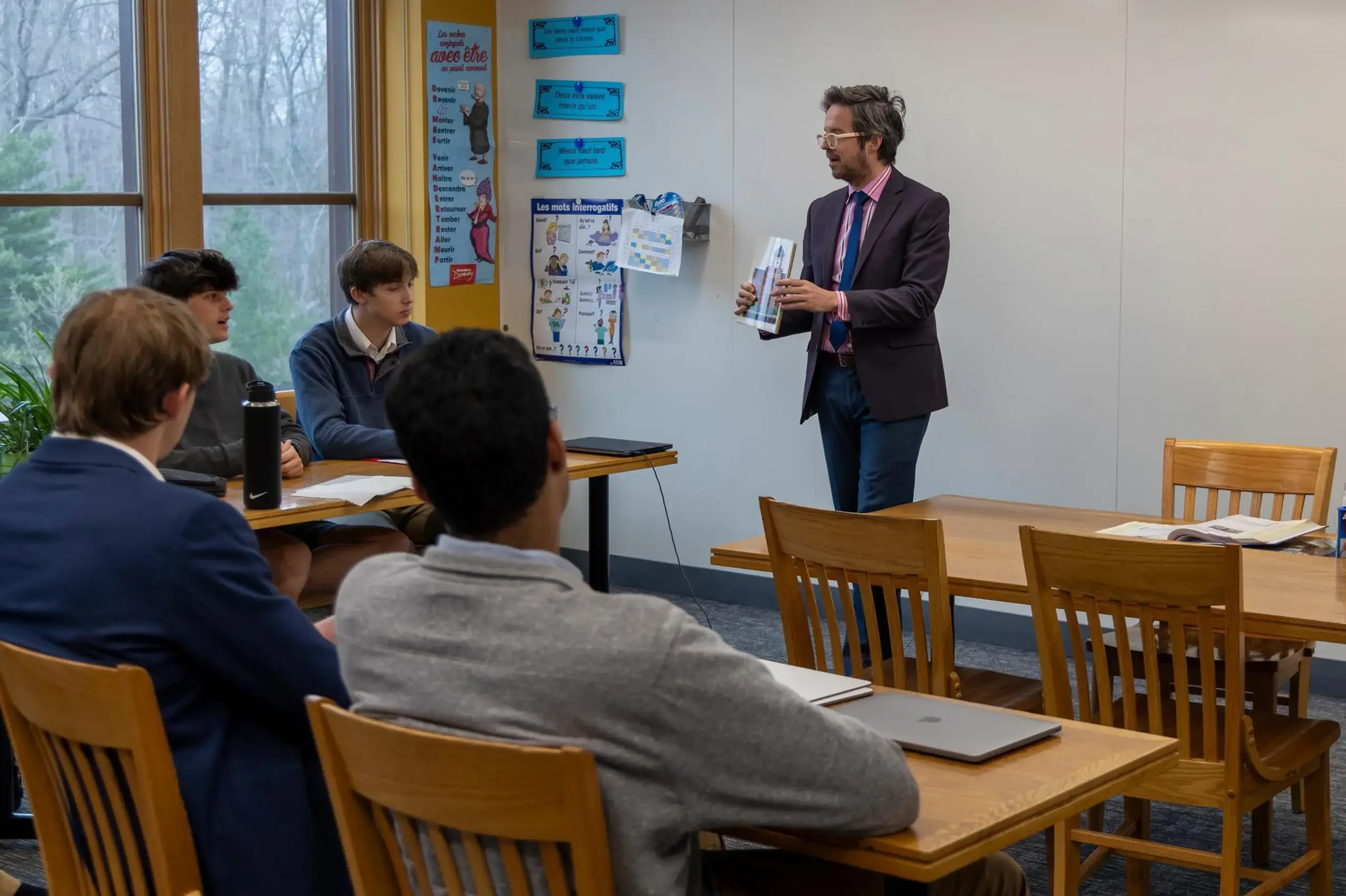 University School Upper School teacher showing a textbook to students in a language class.