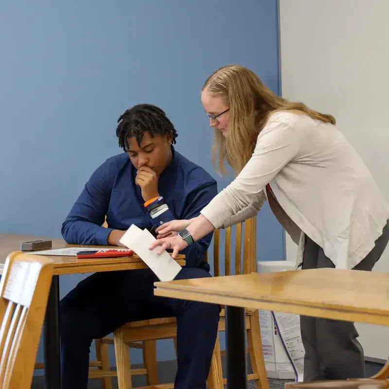 University School Upper School teacher discussing an equation with a student in a math class.